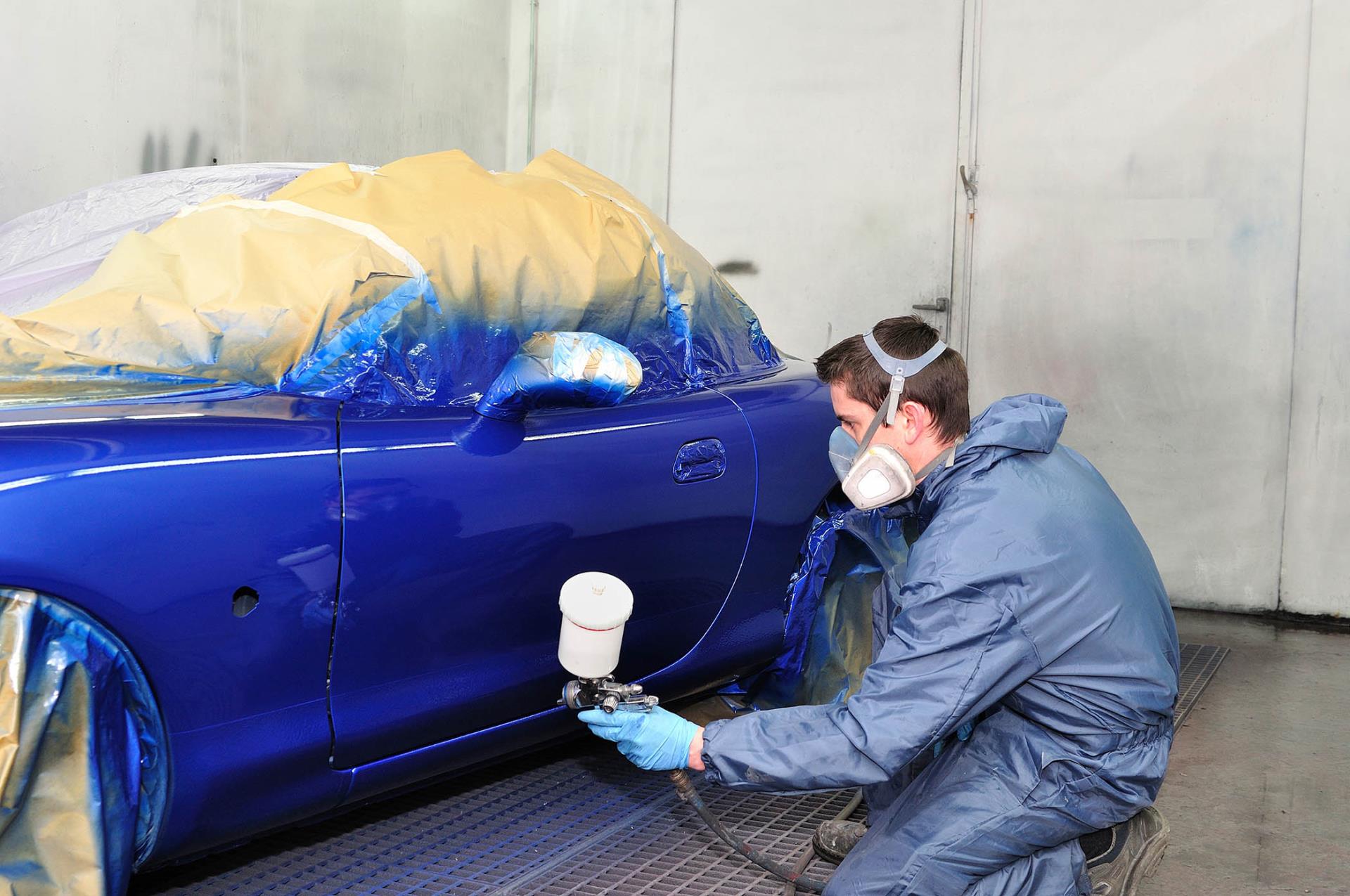 Man working on car in auto body shop