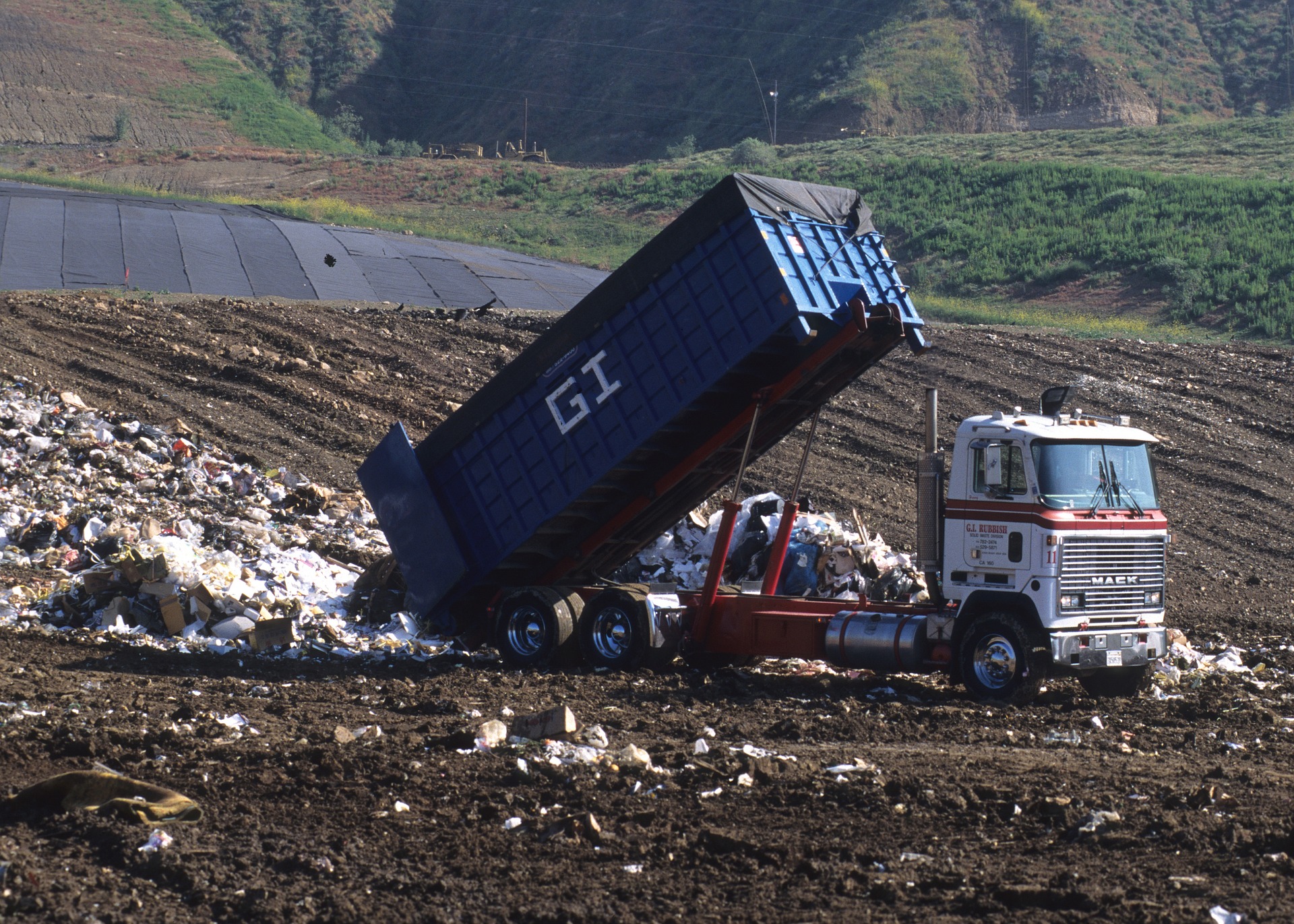 truck dumping garbage in landfill