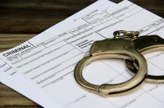 Cuffs on Criminal Paperwork